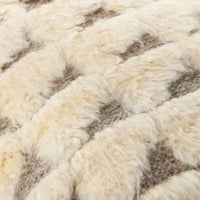 Close-up of a textured woven pillow with thick, fluffy cream-colored material over a taupe-brown base.