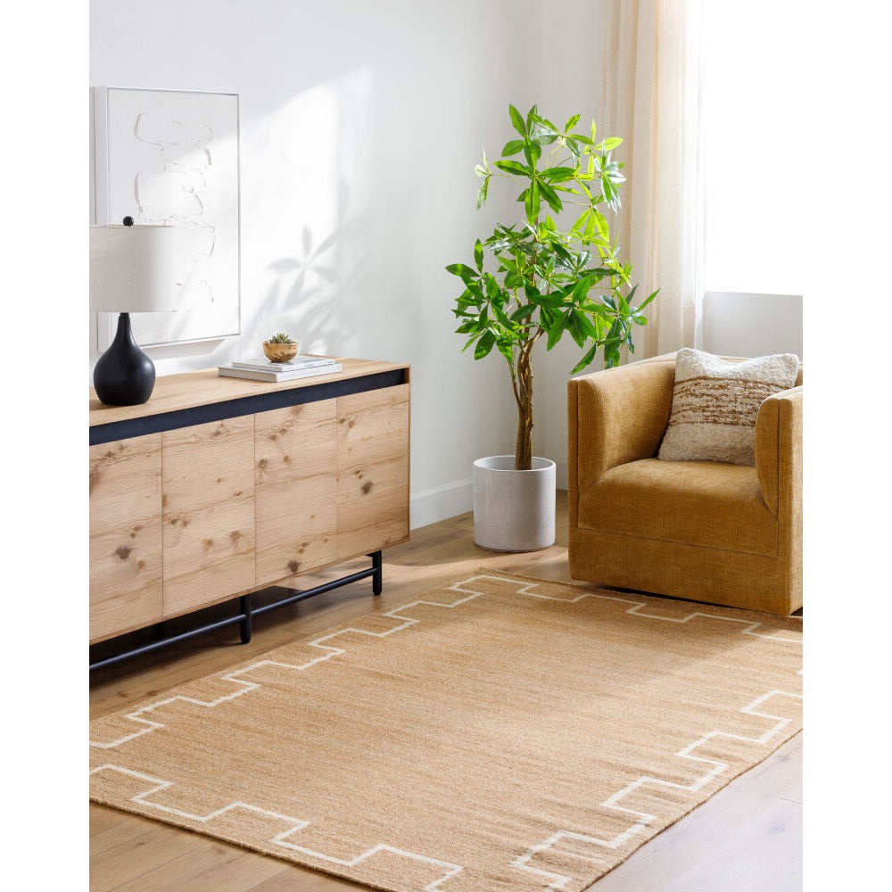 Modern living room with a brown armchair, wooden sideboard, and decorative plant.