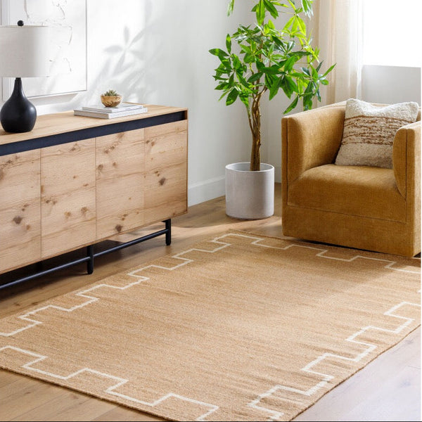 Modern living room with a brown armchair, wooden sideboard, and decorative plant.