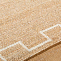 Beige rug with white geometric pattern on wooden floor