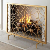The Circles Contemporary Fireplace Screen by Dessau Home features an iron screen with overlapping circles and an antiqued gold finish.
