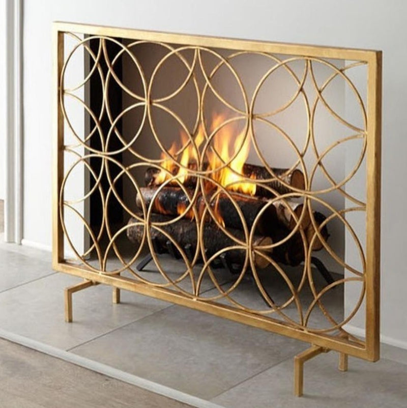 The Circles Contemporary Fireplace Screen by Dessau Home features an iron screen with overlapping circles and an antiqued gold finish.