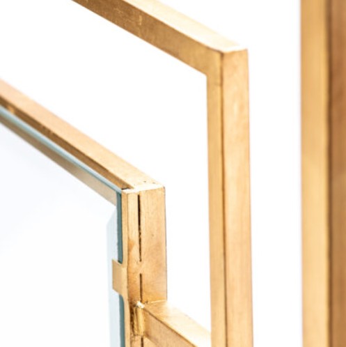 Close-up of the Dessau Home Center Panel Glass Antique Gold Fireplace Screen's corner joint, with sharp lines for a modern twist.