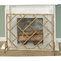 Decorative copper fireplace screen in front of a white fireplace.