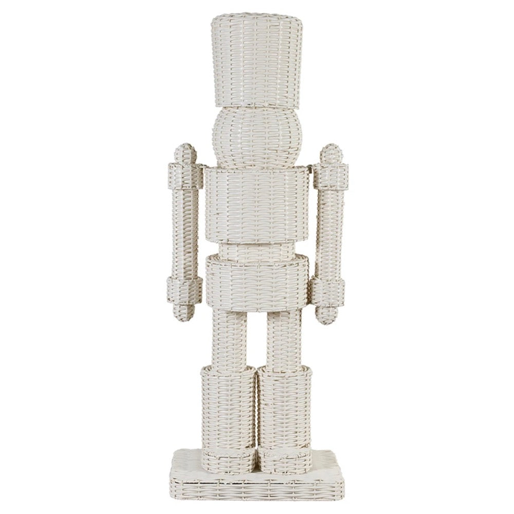 A white woven rattan nutcracker figurine standing on a rectangular base against a plain white background.