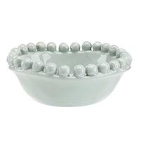 Light blue ceramic bowl with bead-like embellishments on a white background