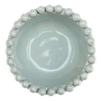 Light blue ceramic bowl with bead-like embellishments on a white background