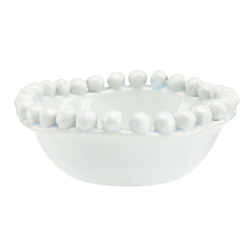 White ceramic bowl with bead-like embellishments on a white background