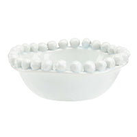 White ceramic bowl with bead-like embellishments on a white background