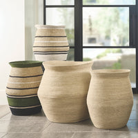 Set of woven baskets in various sizes on a tiled floor with a window in the background.
