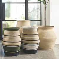 Set of decorative baskets with striped patterns on a tiled floor.