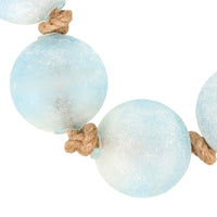 Light blue wooden beads with natural rope on a white background