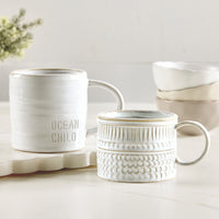 Set of ceramic mugs with 'Ocean Child' text on a light background