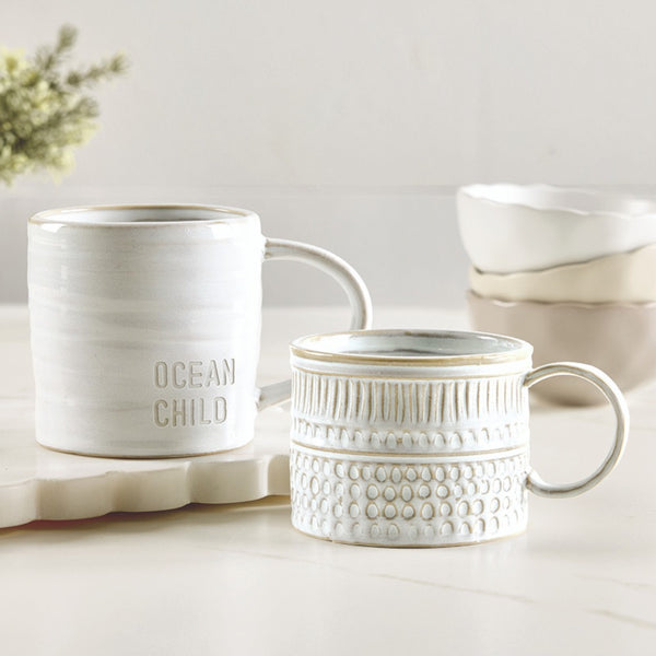 Set of ceramic mugs with 'Ocean Child' text on a light background