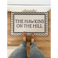 Spicher and Company Mosaic 8th Avenue Personalized Vinyl Mat; person in sandals and jeans stands on it.