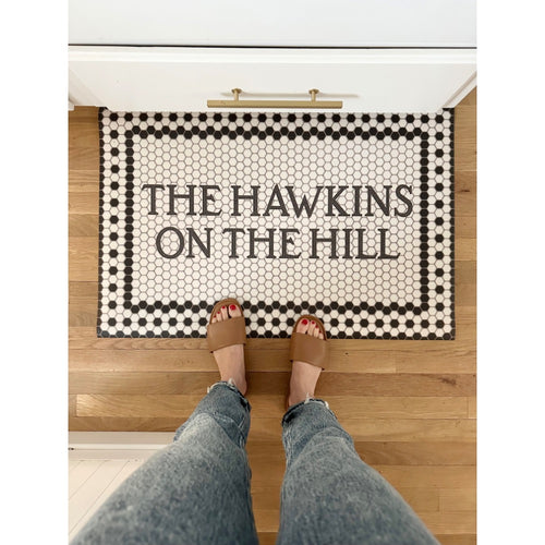 Spicher and Company Mosaic 8th Avenue Personalized Vinyl Mat; person in sandals and jeans stands on it.