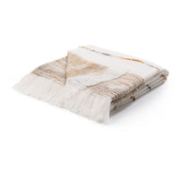 A folded woven throw blanket with fringed edges, featuring a cream and white base with subtle tan, brown, and gray striped patterns, shown on a solid white background.