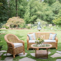 Wicker outdoor furniture set with cushions on a grassy lawn