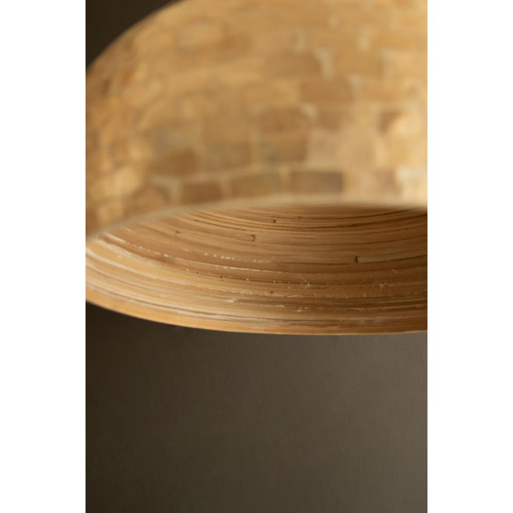 Close-up of a light natural ome shade, showing the layered iridescent capiz shell texture and curved underside, set against a dark brown background.