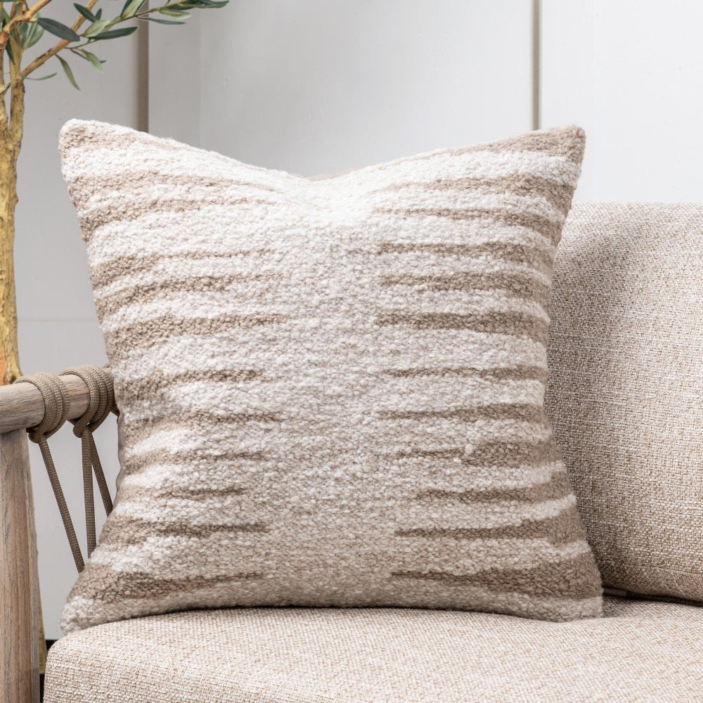 Textured pillow on a beige sofa with a neutral background