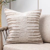 Textured pillow on a beige sofa with a neutral background