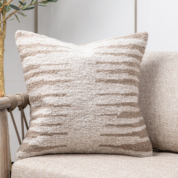 Textured pillow on a beige sofa with a neutral background