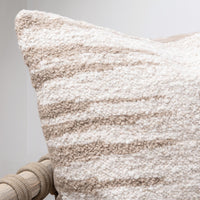 Textured pillow with a neutral color palette on a light gray background