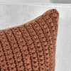 Close-up of Classic Home's Outdoor Performance Prism Terracotta Pillow on a white textured fabric background.