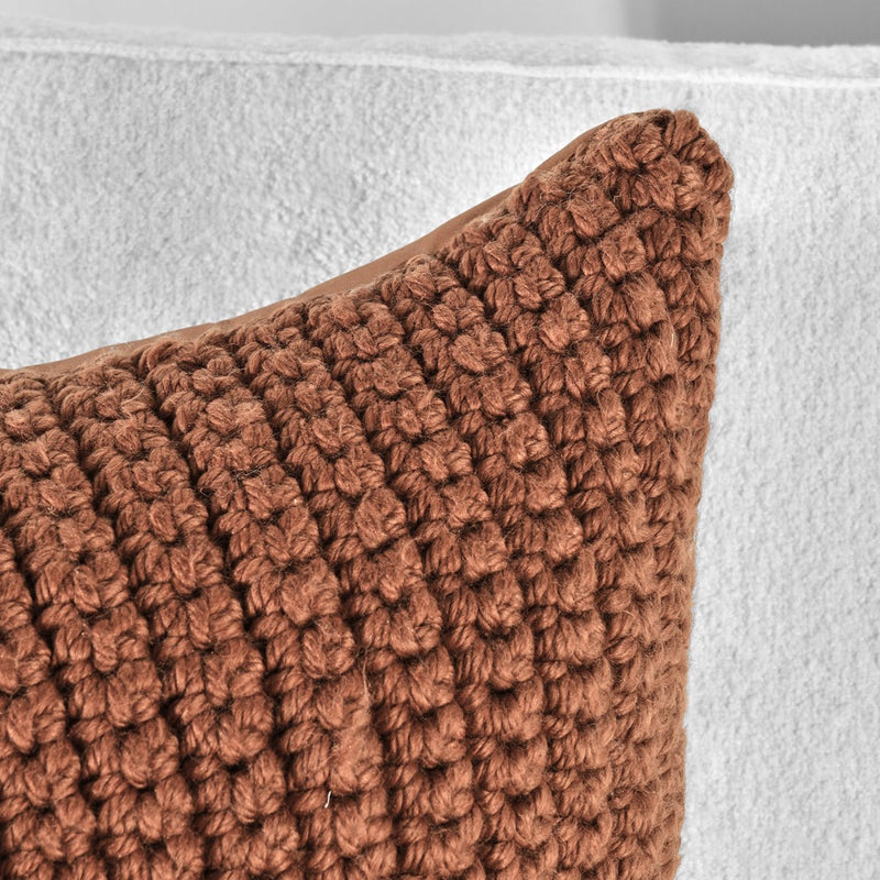 Close-up of Classic Home's Outdoor Performance Prism Terracotta Pillow on a white textured fabric background.