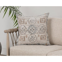 The Classic Home Outdoor Performance Lukens Pillow sits on a light beige sofa with a leafy plant in the background.