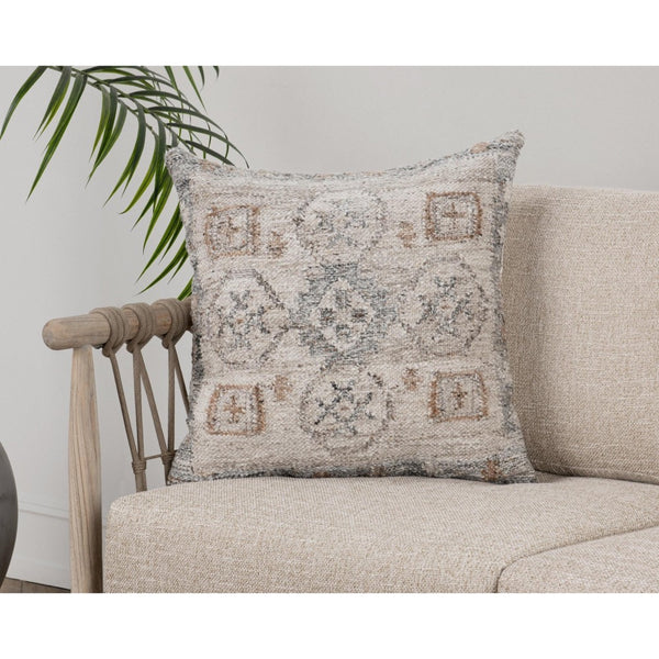 The Classic Home Outdoor Performance Lukens Pillow sits on a light beige sofa with a leafy plant in the background.
