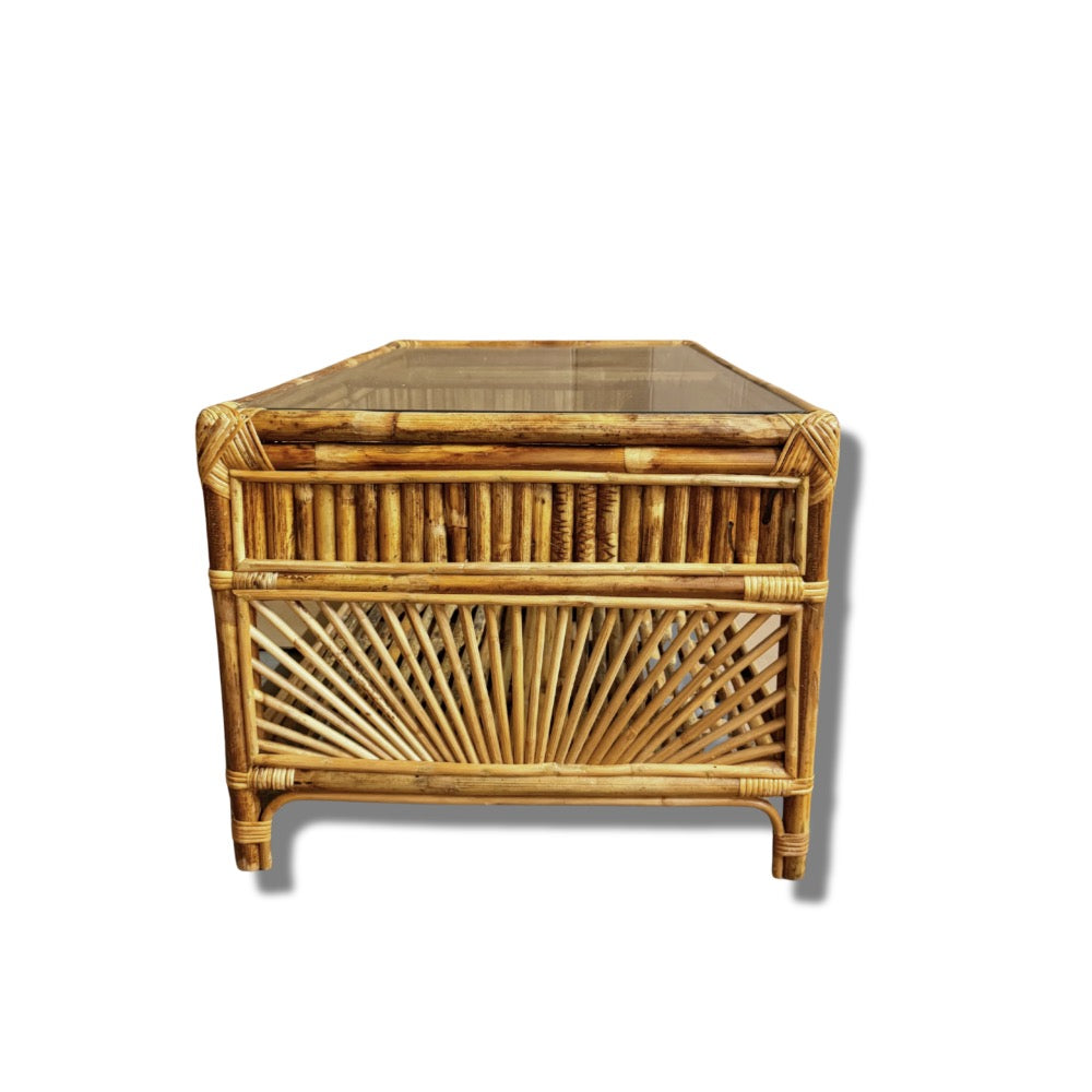 Side view of wicker coffee table with glass top on a white background