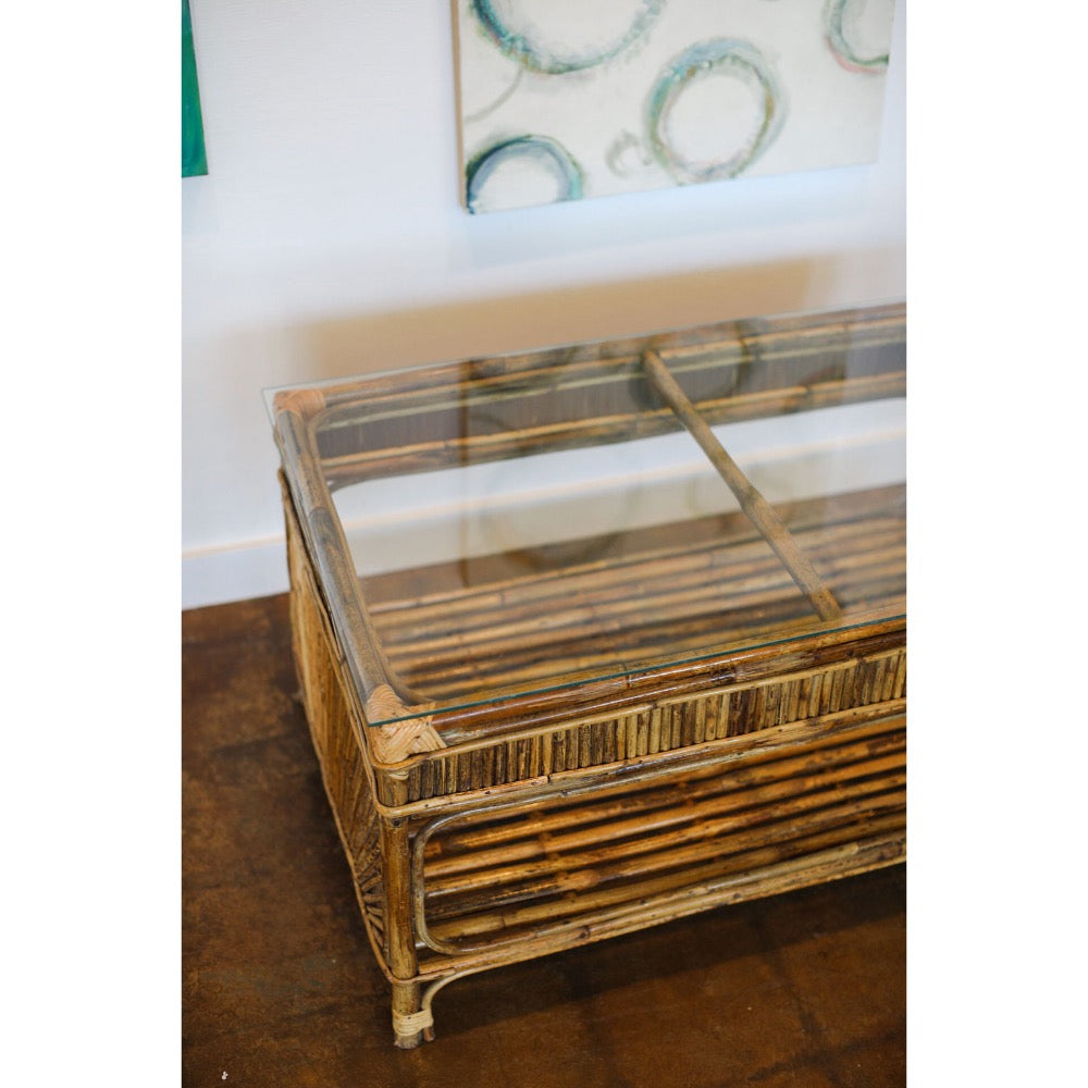 Rattan coffee table with glass top on a wooden floor