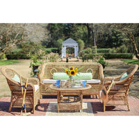 Wicker outdoor furniture set with a table and chairs in a garden setting.