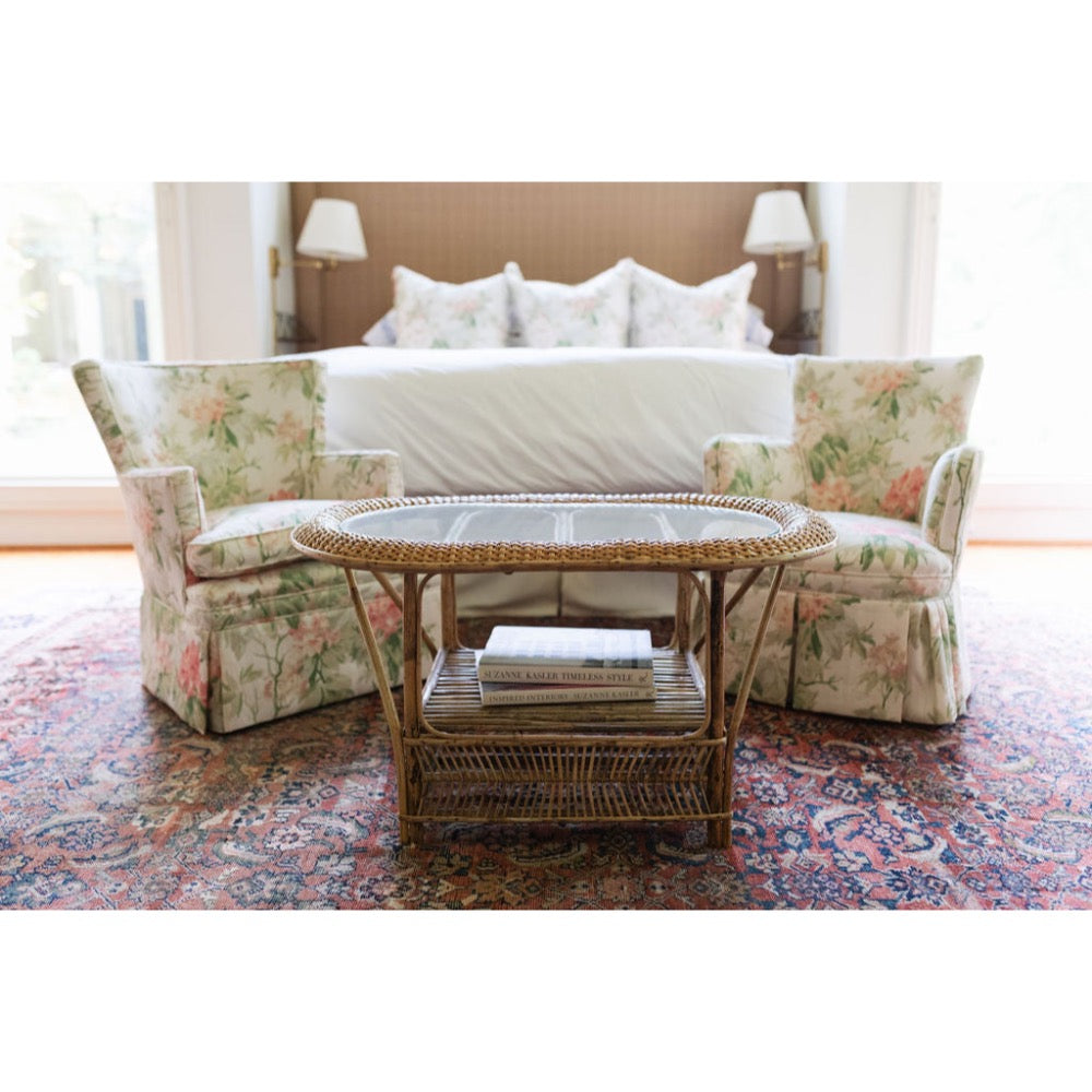 Floral-patterned sofa with a wicker coffee table in a living room setting.