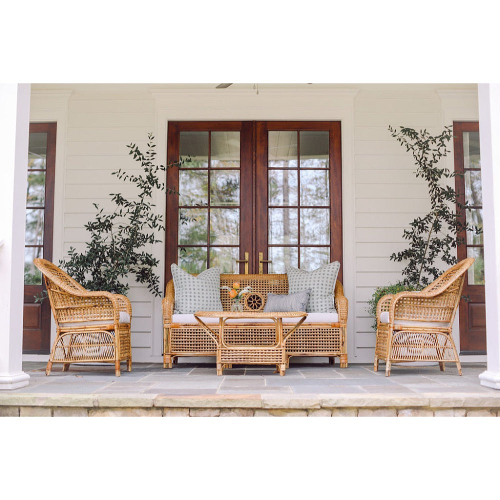 Wicker outdoor furniture set on a porch with decorative elements.