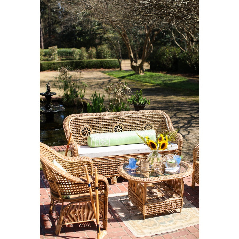 Wicker outdoor furniture set with a table and chairs in a garden setting.