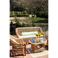 Wicker outdoor furniture set with a table and chairs in a garden setting.