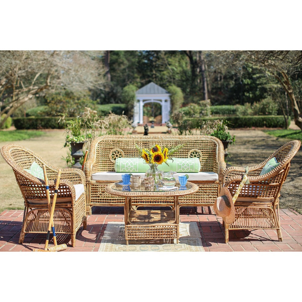 Wicker outdoor furniture set with a table and chairs in a garden setting.