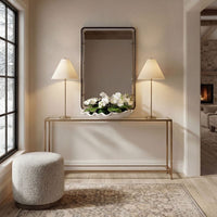 Console table with mirror, lamps, and flowers in a living room setting