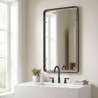 Modern bathroom with Uttermost Bronze Suspended Wall Mirror, black faucet, potted plant, and towels on marble sink.