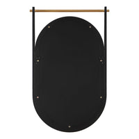 A black back view of oval wall mirror with a natural wood hanging rod and black metal brackets, shown against a plain white background.
