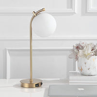 The Uttermost Glass Globe Desk Lamp is shown beside a laptop and flower vase on a sleek white desk.