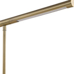 Close-up of the Uttermost Antique Brass Desk Lamp featuring an integrated light system and slim, cylindrical design.