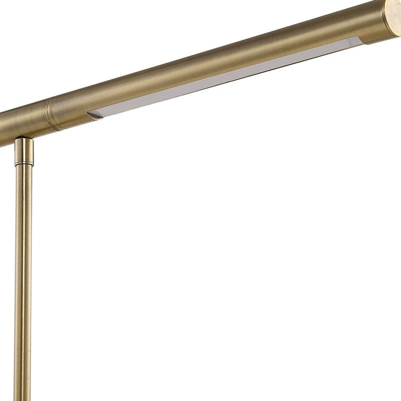 Close-up of the Uttermost Antique Brass Desk Lamp featuring an integrated light system and slim, cylindrical design.