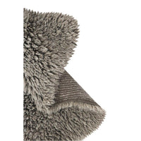 Close-up of a gray shaggy rug with a folded corner showing the textured underside and fringe edge, photographed on a white background.