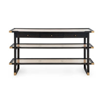 A modern three-tier console table featuring a black frame, light beige woven cane shelves, and a light beige top surface with three small drawers at the top.