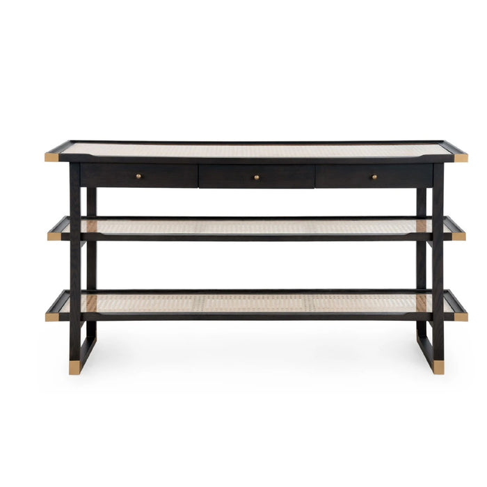 A modern three-tier console table featuring a black frame, light beige woven cane shelves, and a light beige top surface with three small drawers at the top.