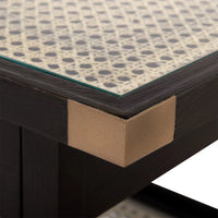 Close-up of a corner where a glass top meets a black frame with cardboard support.