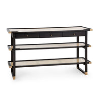 A modern three-tier console table with a black frame, natural woven cane shelves, and three drawers on the top with brass knobs, shown on a white background.